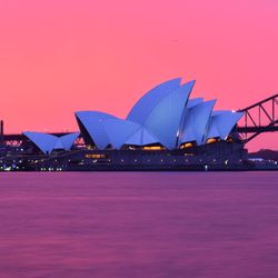 Illuminated city against sky at sunset