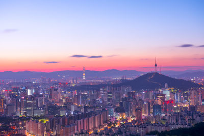 Distant view of n seoul tower against sky during sunset in city