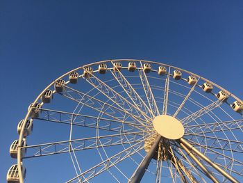 Low angle view of ferris wheel against blue sky