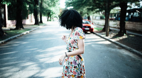 Rear view of woman walking on footpath in city