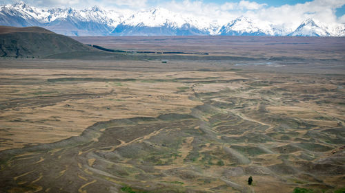 Landscape formed by glacier with snowy mountains in backdrop, shot at tekapo, new zealand