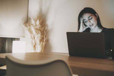 Young woman using laptop at home