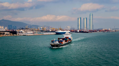 Sailboat in sea against sky in city