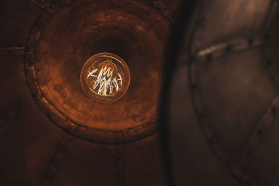 Low angle view of illuminated light bulb in building
