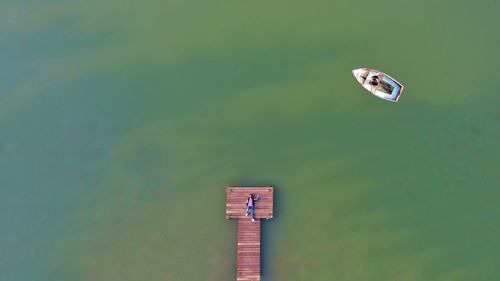 Aerial view of man lying on pier by lake