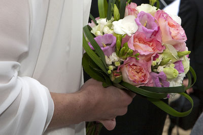 Midsection of man holding bouquet