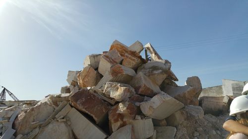 Low angle view of rocks against blue sky