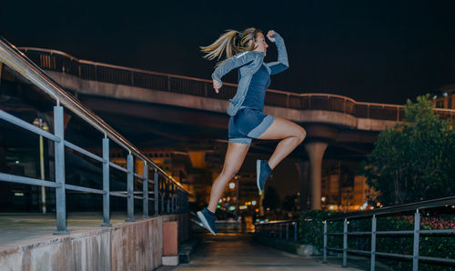 Low angle view of man jumping on railing