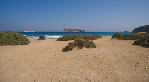 Scenic view of beach against clear blue sky