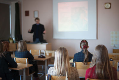 Rear view of students sitting in classroom