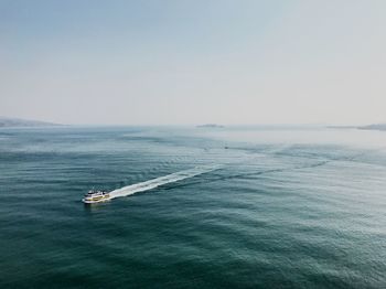 Boat sailing on sea against clear sky