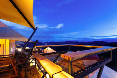 Chairs and tables at restaurant against blue sky