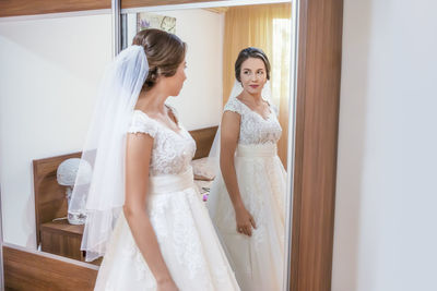 Bride looking in mirror at home