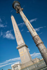 Low angle view of obelisk against blue sky in city