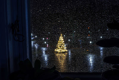 Reflection of people on illuminated building at night