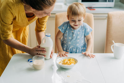 Little toddler daughter spilled milk on the table.