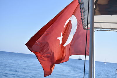 Close-up of red flag against blue sky