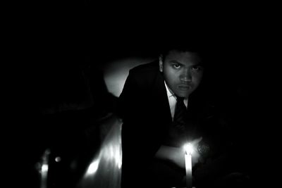 Portrait of young man looking away at night