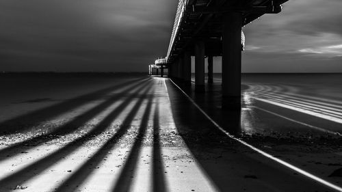 Pier at beach against sky