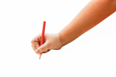 Close-up of hand holding colored pencils against white background