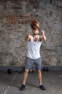 Portrait of young man standing against wall