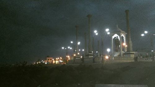 Illuminated street light against sky at night