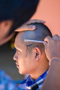 Close-up of man cutting customer hair