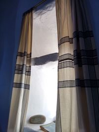 Low angle view of curtained window