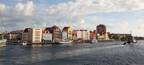 Panoramic view of buildings by river against sky