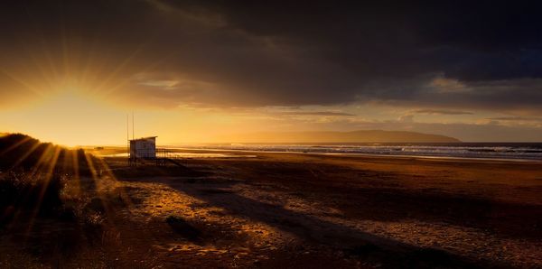 Scenic view of beach against sky during sunset