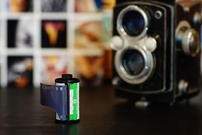 Close-up of roll film and vintage camera on black table