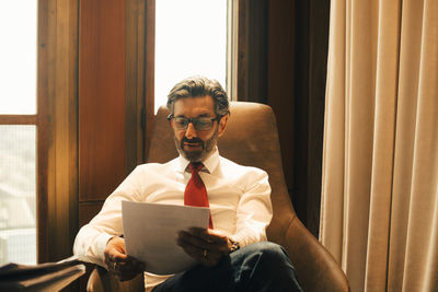 Male financial advisor reading documents at legal office