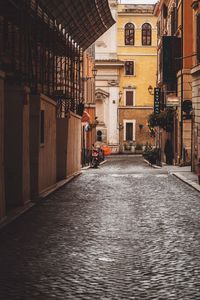 Empty alley amidst buildings in city