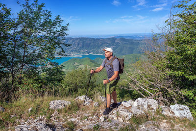 Man looking away while standing on rock