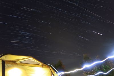 Low angle view of illuminated trees against sky at night