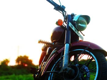 Close-up of bicycle on field against clear sky