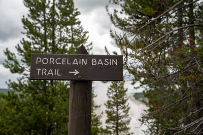 Low angle view of information sign against trees