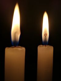 Close-up of lit candle in darkroom