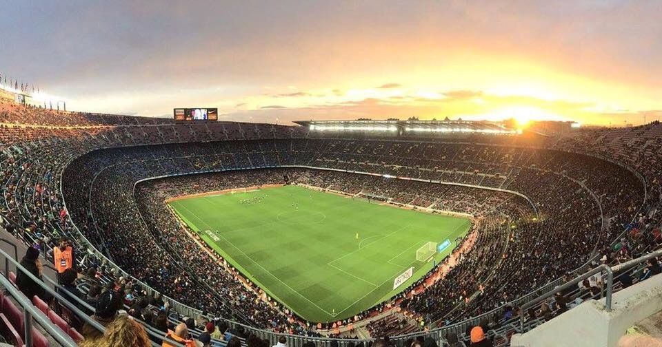 GROUP OF PEOPLE ON SOCCER FIELD AGAINST SUNSET