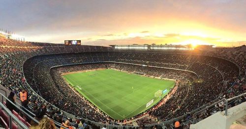 Group of people on soccer field against sunset sky