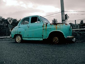 Vintage car on road against sky in city