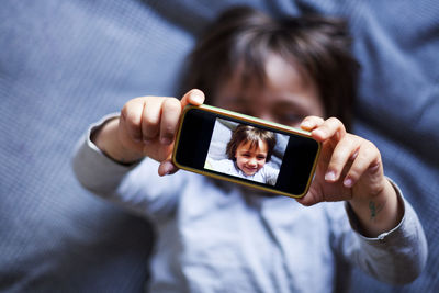 Little boy taking selfie with smartphone