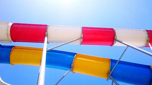 Low angle view of multi colored umbrellas against blue sky