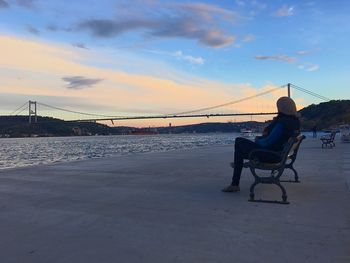 Man on bridge over sea against sky