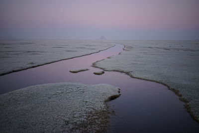 Scenic view of sea against clear sky at sunset