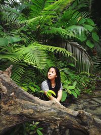 Portrait of smiling young woman against tree
