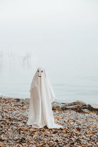 Rear view of woman standing at beach