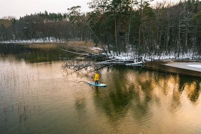 Supboarding in winter at sunset. cold weather sup paddling