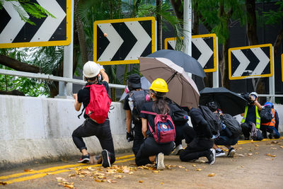 Rear view of people walking on road in city