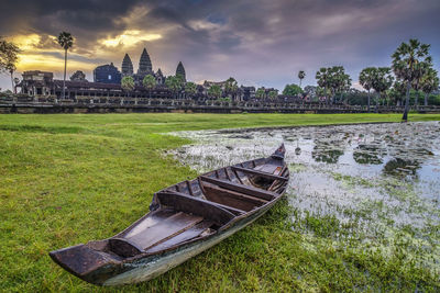 Angkorwat at down with boat foreground near big pond in front of the temple and beautiful sunrise 
